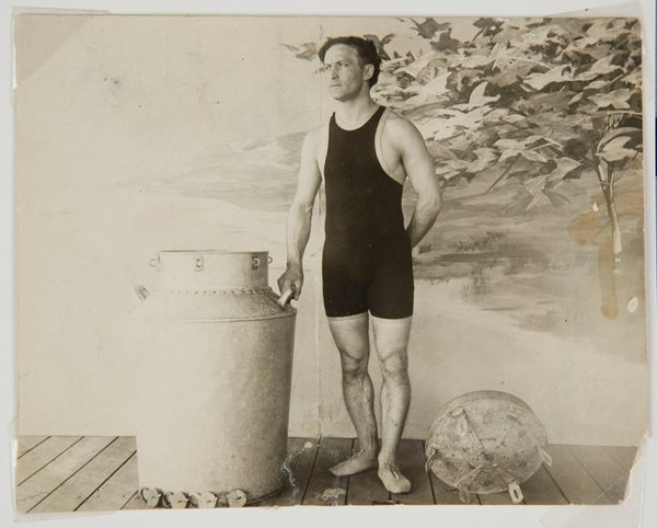 Harry Houdini prêt à s'immerger dans un pot d'acier alors qu'il est attaché.